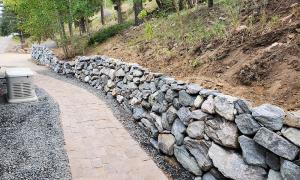 After photo of a sloped yard with a retaining wall. 